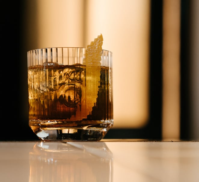 A cocktail with an orange garnish twist.