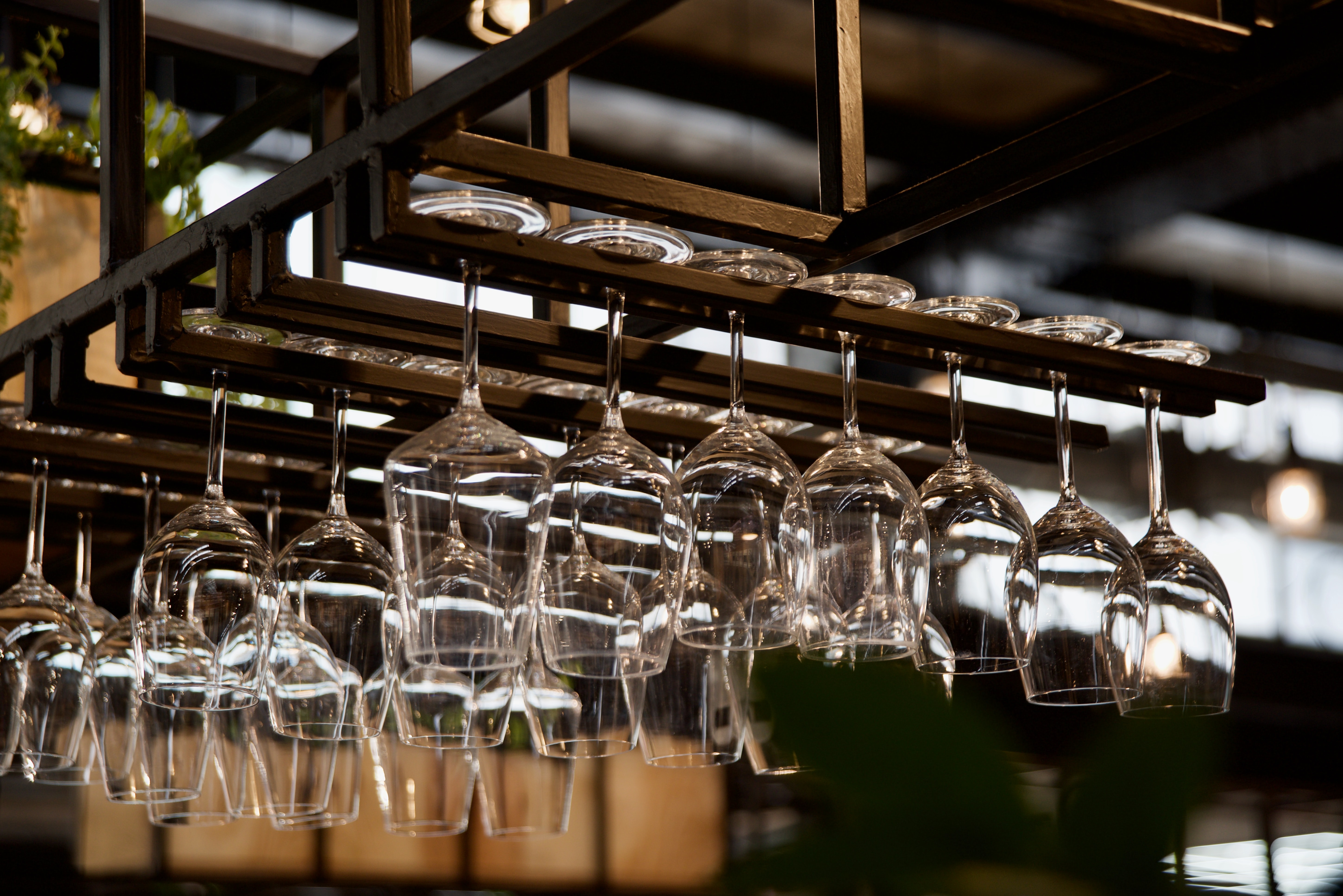 An overhead glass rack of wine glasses.