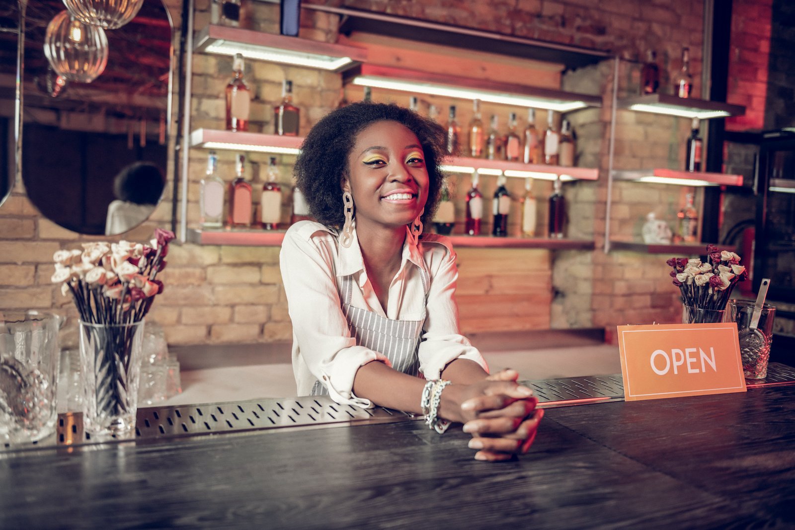 Black woman behind bar.