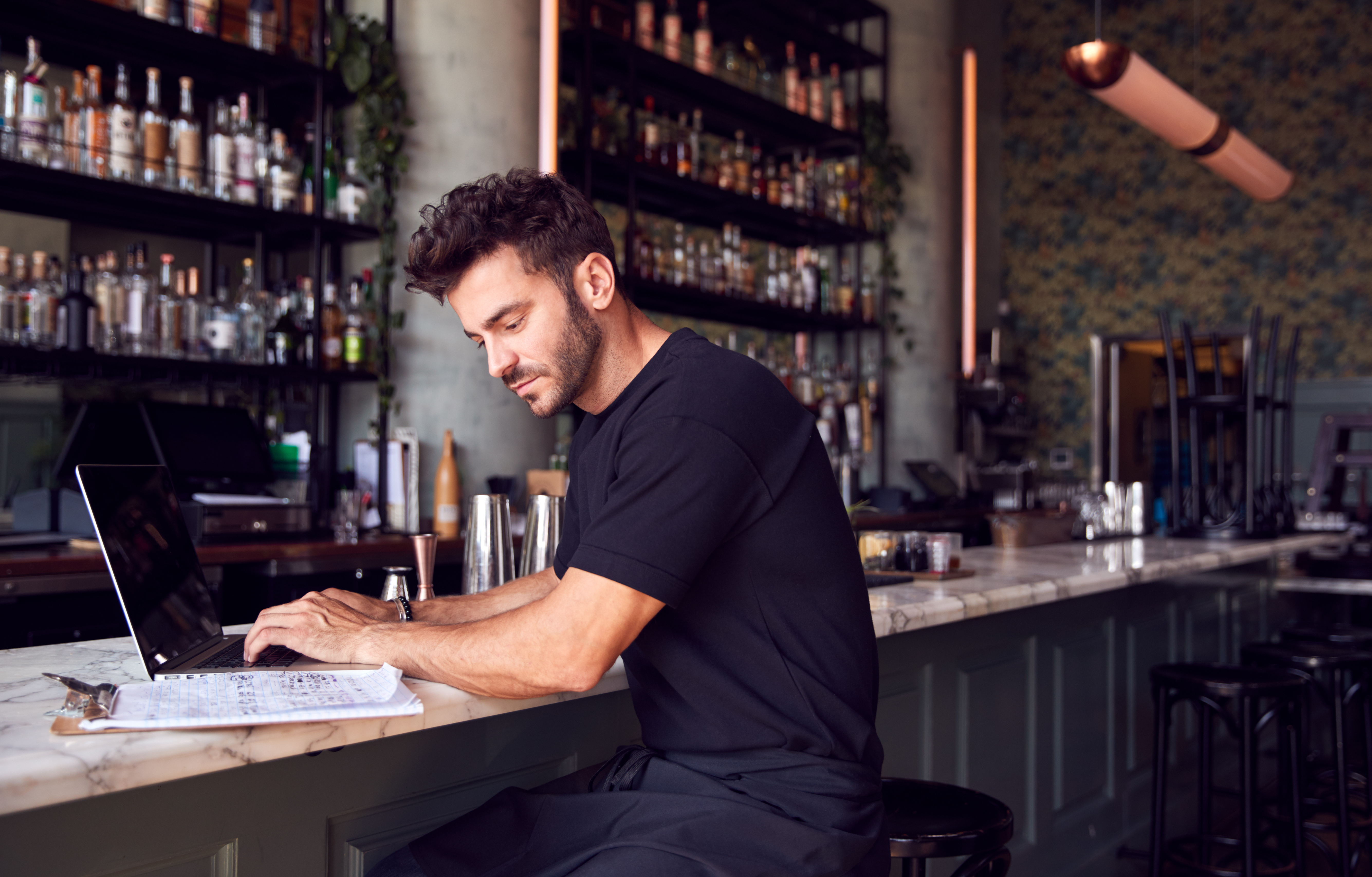 Guy putting in inventory excel formulas at a bar