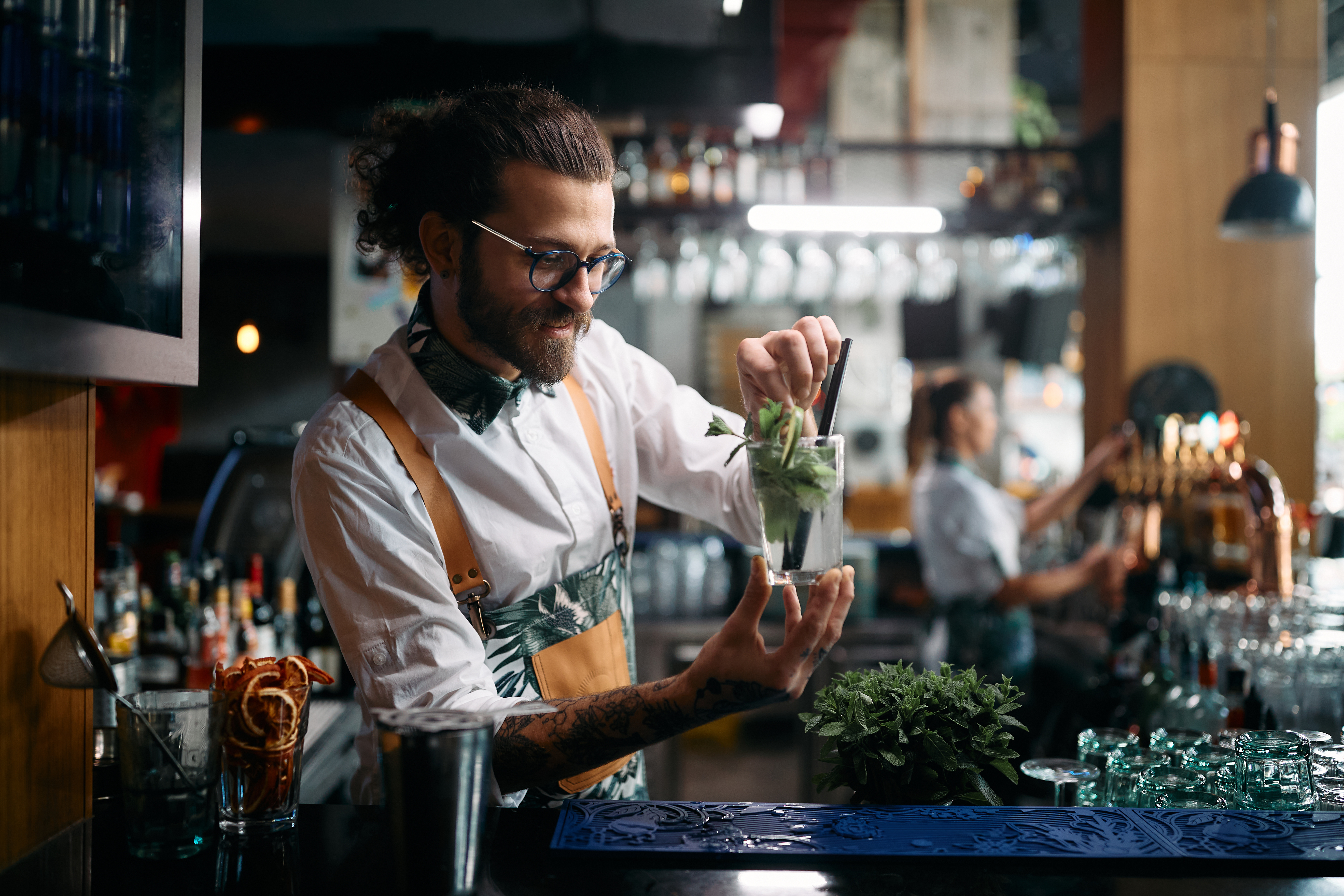 A bartender making drinks behind the bar