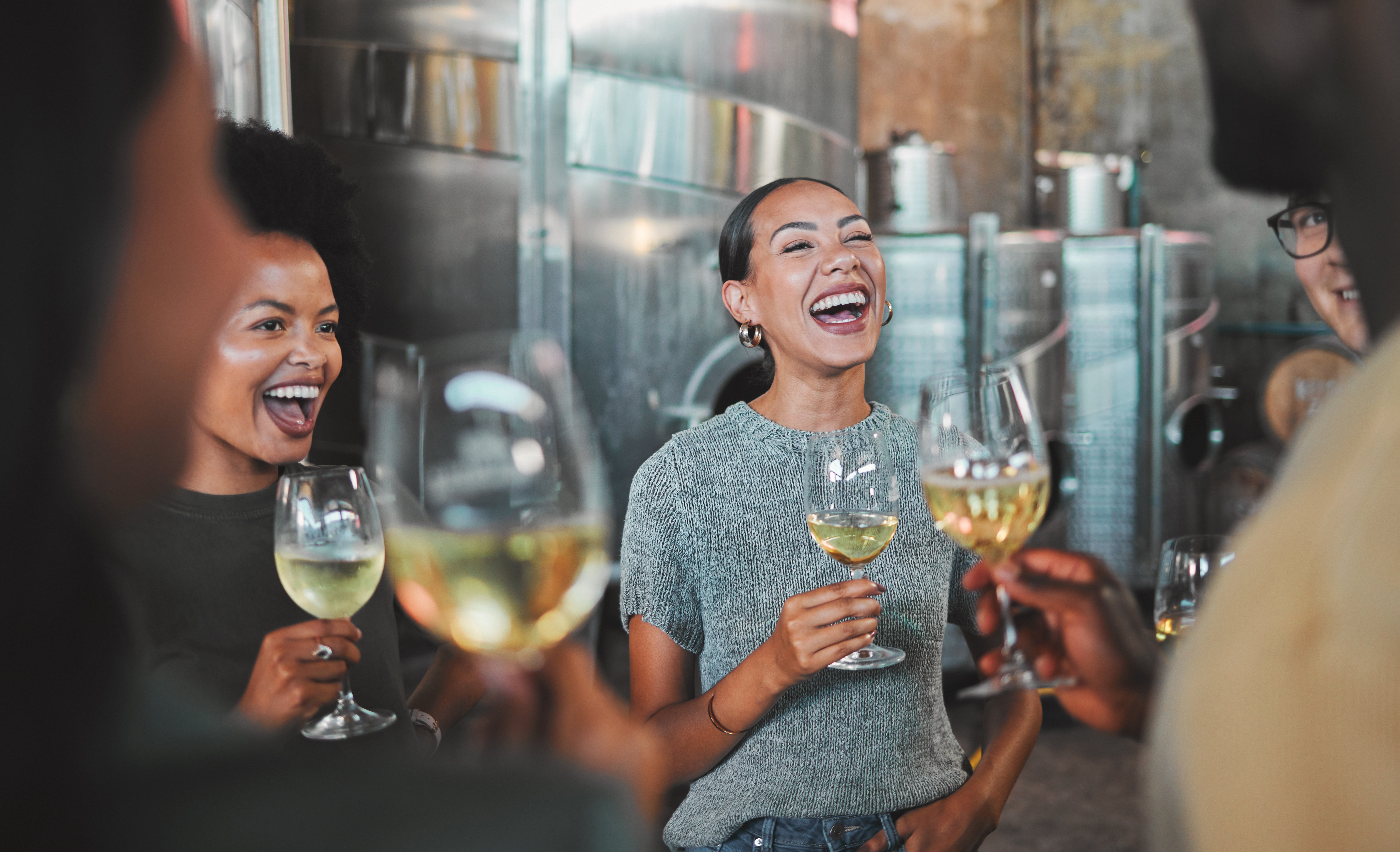 women drinking wine in a winery