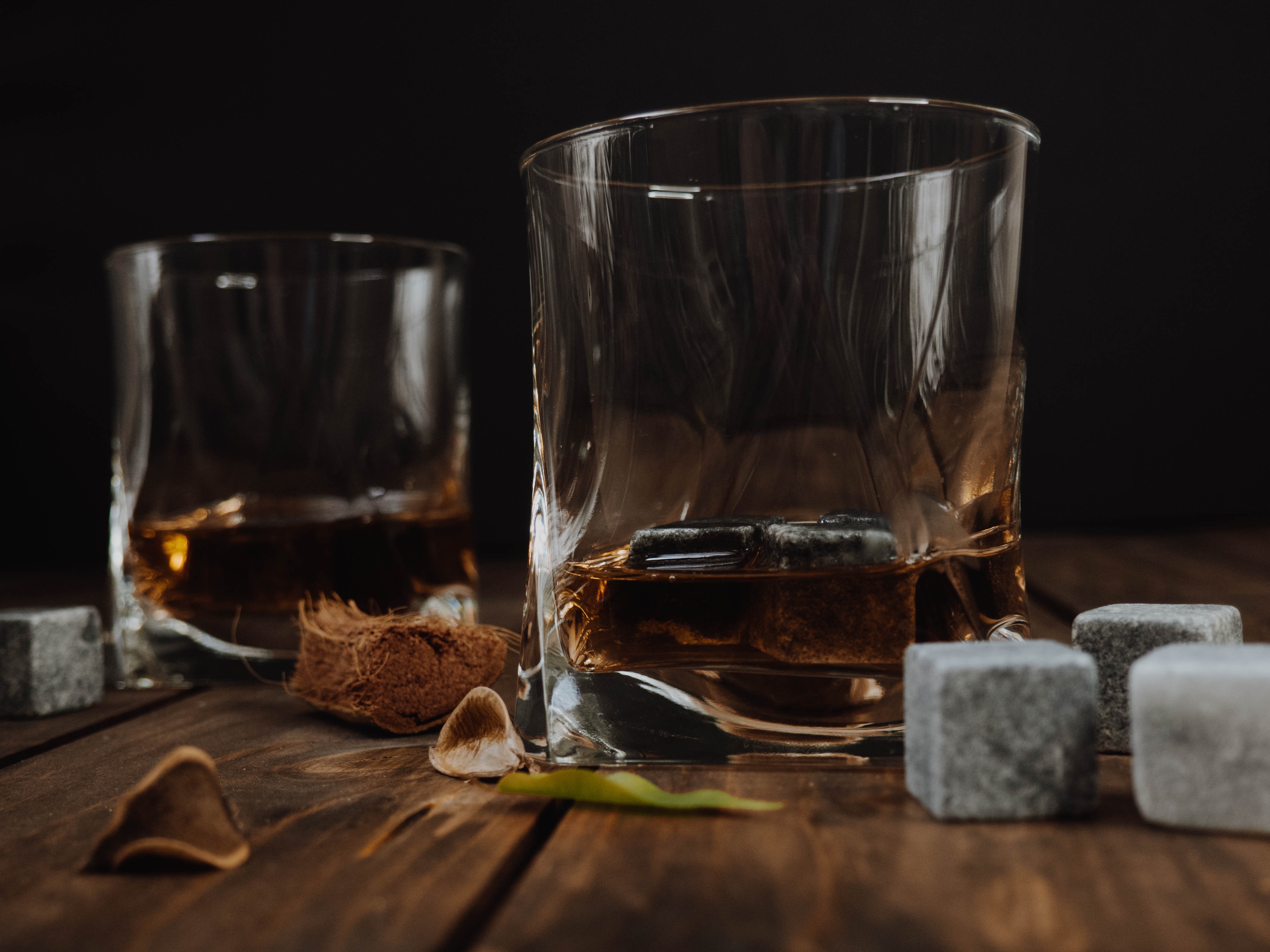 Two glasses of bourbon with whiskey rocks.